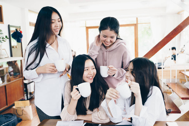 Συνάδελφοι επιχειρηματικές γυναίκες ομάδα brainstorm σε απευθείας σύνδεση στρατηγική maketing στο γραφείο με φορητό υπολογιστή κρατήσει φλιτζάνι καφέ - Φωτογραφία, εικόνα