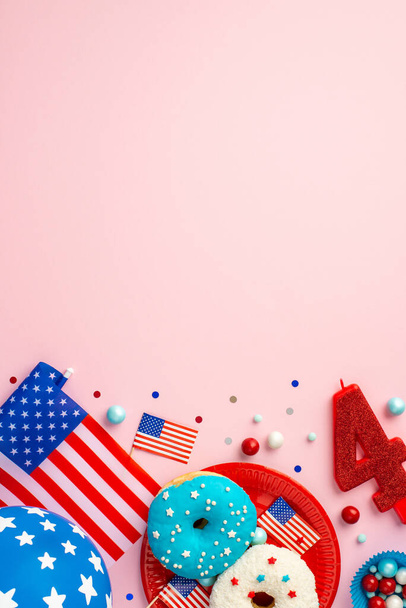 Vierter Juli Konzept. Vertikale Ansicht der US-Nationalflaggen Nummer 4 Kerzenpapierformen mit Süßigkeitsteller mit Donuts Ballon und Konfetti auf isoliertem pastellrosa Hintergrund mit Kopierraum - Foto, Bild