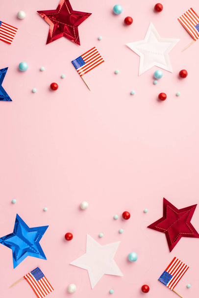 USA Independence Day concept. Bovenaanzicht verticale foto van Amerikaanse nationale vlaggen ster slinger en verspreid snoep op geïsoleerde pastel roze achtergrond met copyspace - Foto, afbeelding
