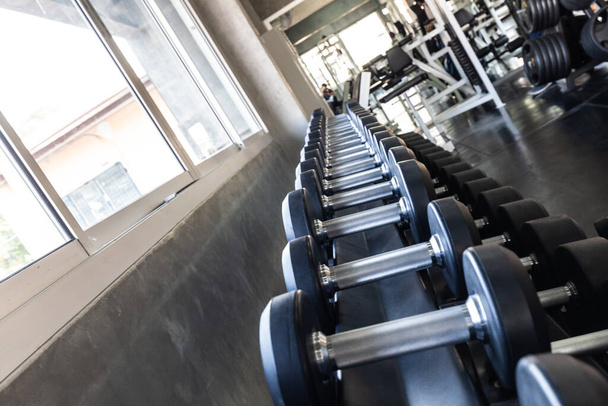 Dumbbell row on shelf in sport gym fitness equipment - Foto, afbeelding