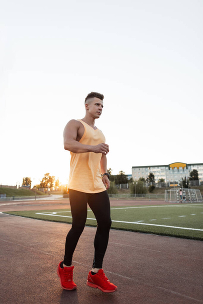 Largometraje completo de un joven sano corriendo en el estadio. corredor masculino corriendo al aire libre. - Foto, Imagen