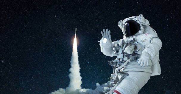 Космічний чоловік у космічному костюмі і капелюсі подорожує у відкритому космосі і хвилює руку на тлі ракетного підйому. Космічний корабель успішно злітає. Ласкаво просимо в космос, концепція
 - Фото, зображення