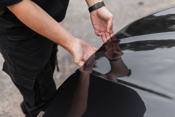 Man's hands open the hood of the car. Professional car mechanic guy starts to work, concept - 写真・画像
