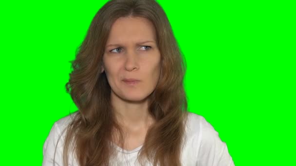 Grappig portret van jonge verveelde vrouw die in haar neus peutert, dom grappig gezichtconcept. Groene chroma sleutel zelfs achtergrond. Statisch schot. 4K UHD - Video