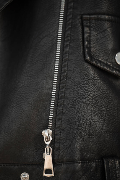 Textura de uma jaqueta de couro com um zíper metálico. Textura de fundo de couro preto. Menina em uma jaqueta na moda, close-up - Foto, Imagem