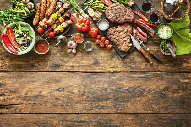 Grillowane mięso i warzywa na drewnianym stole piknikowym - Zdjęcie, obraz
