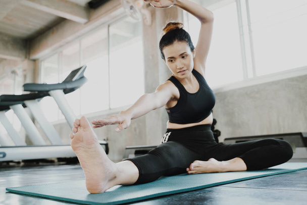 Jonge Aziatische sportieve aantrekkelijke vrouw oefenen yoga in sportschool training en lifestyle concept - Foto, afbeelding