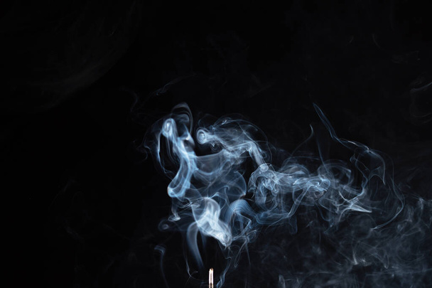 incense stick with smoke against black background - Foto, afbeelding