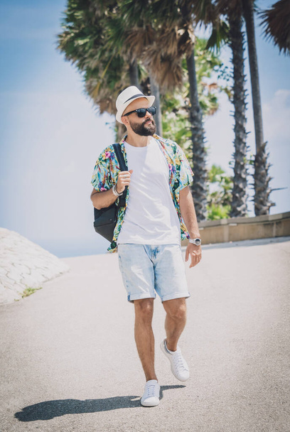 Young traveler man at summer holiday vacation with beautiful palms and seascapes at background. - Fotoğraf, Görsel