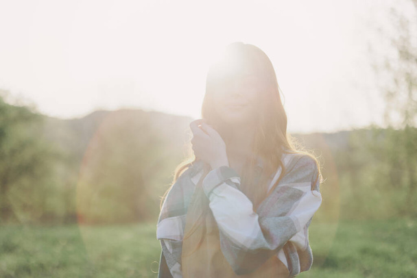 Ritratto di donna con un bel sorriso e denti dritti in una giornata estiva al tramonto con i capelli ricci volanti. Foto di alta qualità - Foto, immagini