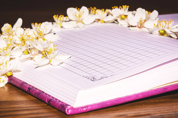 White color on the leaves of a notebook. Paper in flowers - Photo, Image