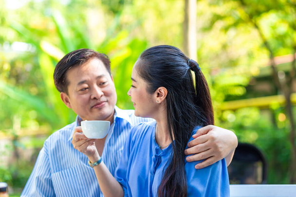 Щаслива азіатська старша пара приймає кавовий напій в зеленому саду щасливий ранок
 - Фото, зображення