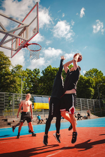 Lviv, Ucrania - 28 de mayo de 2022: hombres jugando al baloncesto al aire libre soleado día de verano - Foto, Imagen