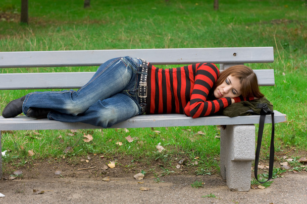 Chica durmiendo en un banco del parque
 - Foto, imagen