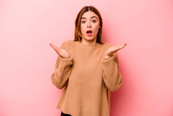 Young caucasian woman isolated on pink background surprised and shocked. - Foto, immagini