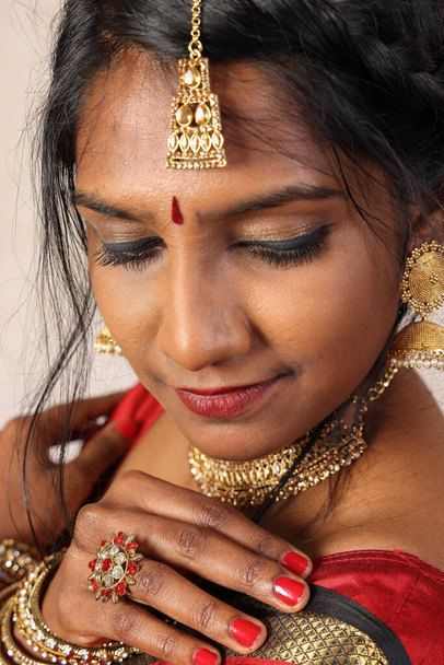 Индийская женщина в красном оранжевом сари ювелирные украшения choker набор ожерелье jhumka серьга Maang tikka талии цепи стоять поза смотреть смотреть улыбку выражение лица  - Фото, изображение