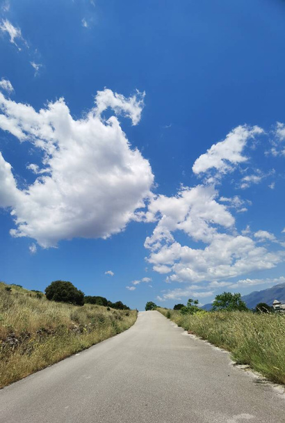 road street clouds uphil path vivid spring color on the sky travel outdoors - Photo, Image
