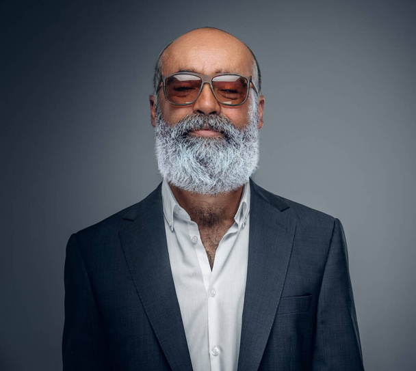 Idős üzletember, szakállal és napszemüveggel, elegáns öltönyben.. - Fotó, kép
