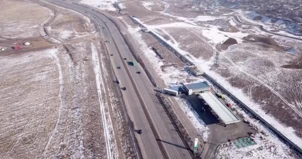 A large truck is traveling on a multi-lane highway. Around the steppe, snow and emptiness. Cloudy weather, winter. The trucker continues on his way. Cars overtake. Transport company. Kazakhstan. - Footage, Video