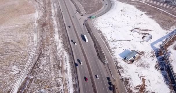A large truck is traveling on a multi-lane highway. Around the steppe, snow and emptiness. Cloudy weather, winter. The trucker continues on his way. Cars overtake. Transport company. Kazakhstan. - Footage, Video