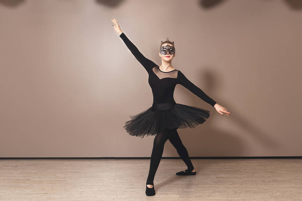 Прекрасная изящная балерина в черном лебедином платье. Молодой балетный танцор перед выступлением в черной пачке, студия классического танца, копировальное пространство
 - Фото, изображение