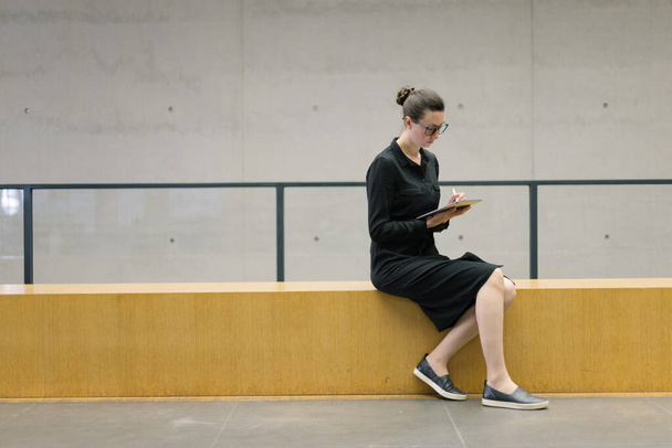 Woman working using tablet pc in minimalist office workspace - Foto, Bild