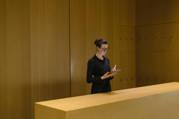 Woman working using tablet pc in minimalist office workspace - Fotó, kép