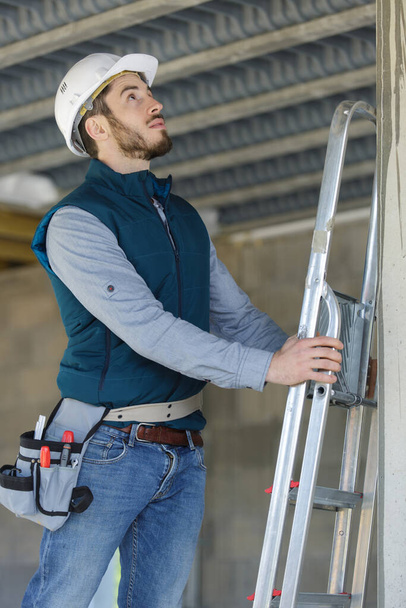 male builder on ladder - Foto, afbeelding