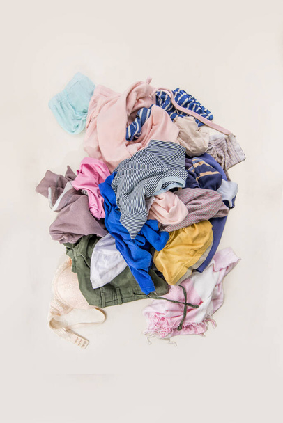 Used clothes in a pile. Sorting second-hand for recycling. Copy space on white background. Top view - Фото, изображение