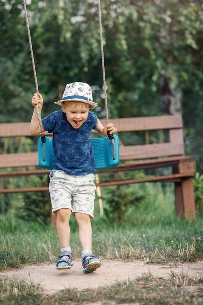 Young boy having fun on rope swing, he falls off the swing. - Valokuva, kuva