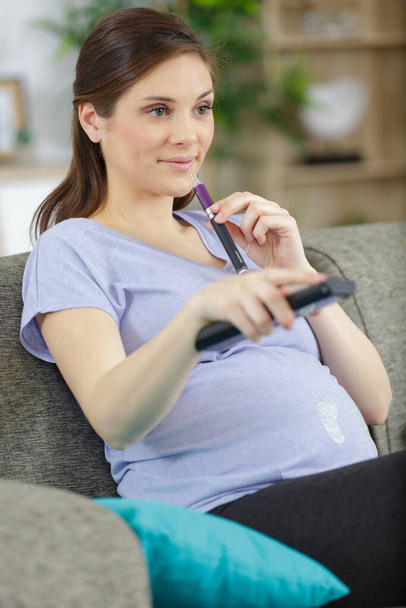 closeup shot of pregnant woman watching tv - Фото, зображення