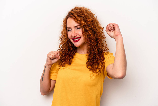 Young ginger caucasian woman isolated on white background celebrating a special day, jumps and raise arms with energy. - Photo, Image