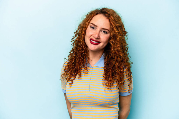 Young ginger caucasian woman isolated on blue background happy, smiling and cheerful. - Photo, Image