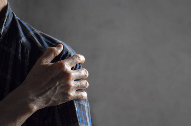 Schmerzen im Schultergelenk eines südostasiatischen älteren Mannes. Konzept der eingefrorenen Schulter. - Foto, Bild