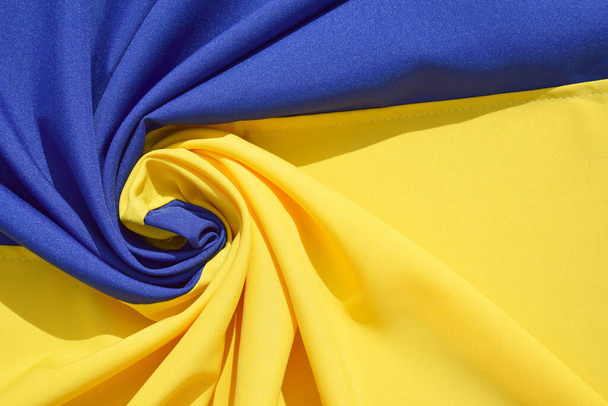Fabric ohnul národní vlajku Ukrajiny, UA. Modrá a žlutá barva. Detailní záběr, pozadí. - Fotografie, Obrázek