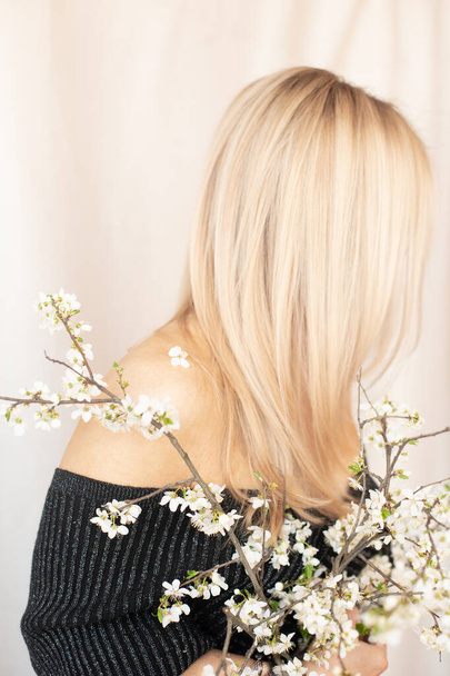 blonde girl with a spring bouquet of cherry blossoms gentle concept sprin - 写真・画像