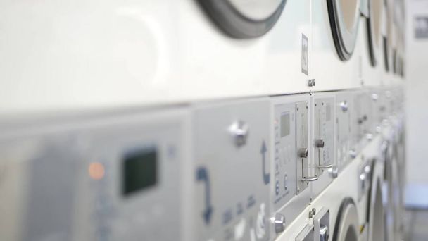 Mosó- és szárítógépek sora, pénzmosás Kaliforniában, USA-ban. Önkiszolgáló mosodában vagy kereskedelmi mosodában használt mosógépek és szárítók. Automatikus mosás az Egyesült Államokban. - Fotó, kép