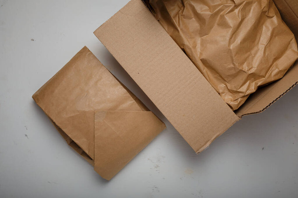Natuurlijk papierpakket, karton op witte achtergrond. Milieuvriendelijk, geen plastic pakketverpakking. Zorg voor milieu, mindfulness over ecologie - Foto, afbeelding