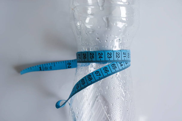 Botella de cinta de agua centímetro sobre un fondo claro - Foto, imagen