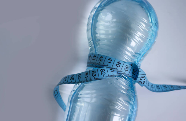 Botella de cinta de agua centímetro sobre un fondo claro - Foto, Imagen