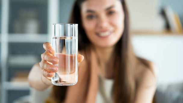 若い女性がコップ一杯の水を飲み - 写真・画像