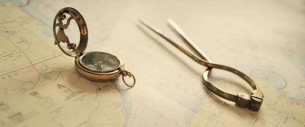 Antique W HC 6" brass dividers calipers nautical navigation chart tool, compass (sun dial), white map close-up. Vintage still life. Sailing, travel accessories. Planning, concept art - Foto, imagen