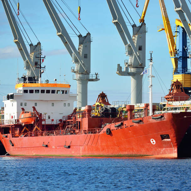 Nákladní lodě nakládají v přístavním terminálu. Jeřábi v pozadí. Baltské moře. Zásobování, výroba paliva a elektřiny, dodávky, technologie, logistika, služby, průmysl, obchod - Fotografie, Obrázek