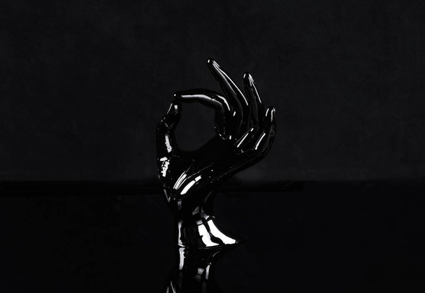 black artificial hand on a black background - Photo, Image