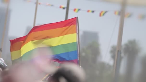 Bandera de arco iris LGBTQ ondeando en cámara lenta durante la fiesta principal en un desfile de orgullo - Imágenes, Vídeo