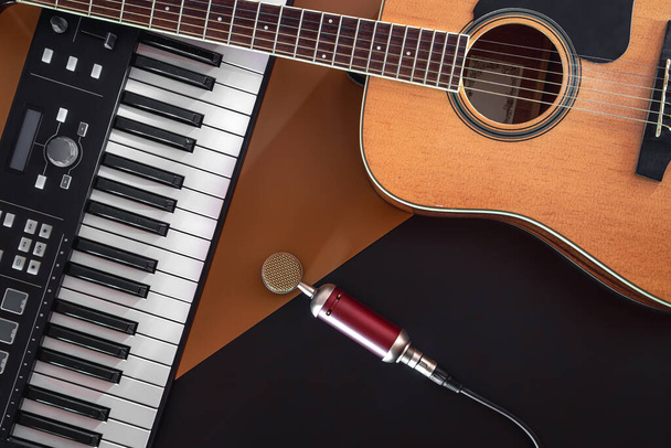 Flat lay, musical composition with acoustic guitar, piano and microphone. - Photo, Image