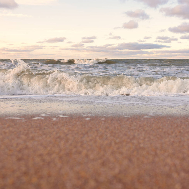 Балтійський морський берег (піщані дюни) на заході сонця. М'яке світло, чисте небо з яскравими хмарами, хвилями і сплесками води. Ідилічний морський мис. Лієпая, Латвія, Європа. Тепла зима, зміна клімату, природа - Фото, зображення