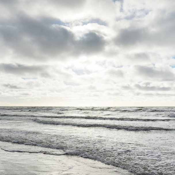Baltic sea after the storm. Dramatic sky, glowing clouds, soft sunlight. Waves, splashing water. Picturesque scenery, seascape, nature. Panoramic view - Photo, Image