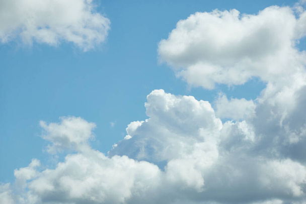 Облачный пейзаж. Белые декоративные облака. Мягкий солнечный свет. Ясное голубое небо. Естественный узор, текстура, фон, обои, графические ресурсы, дизайн, копировальное пространство. Символ мира - Фото, изображение