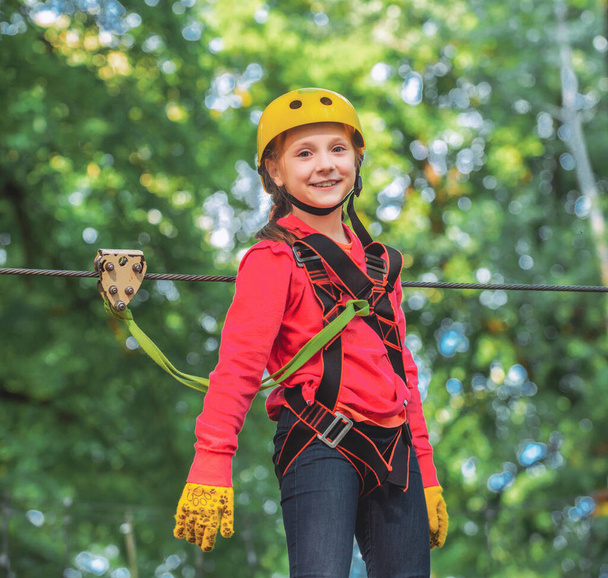 Little girl climbing on high rope park. Roping park. Rope park. Small boy enjoy childhood years. Balance beam and rope bridges. Little girl playing on the playground - Foto, Imagen